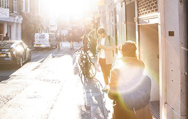 Guy looking at phone behind sunlight